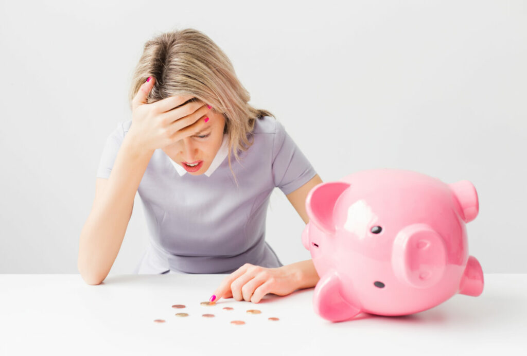 More than nine in ten CMOs say that staying informed about agency investments and fostering open communication boosts financial returns, here depicting a person stressed about moeny in front of a piggy bank