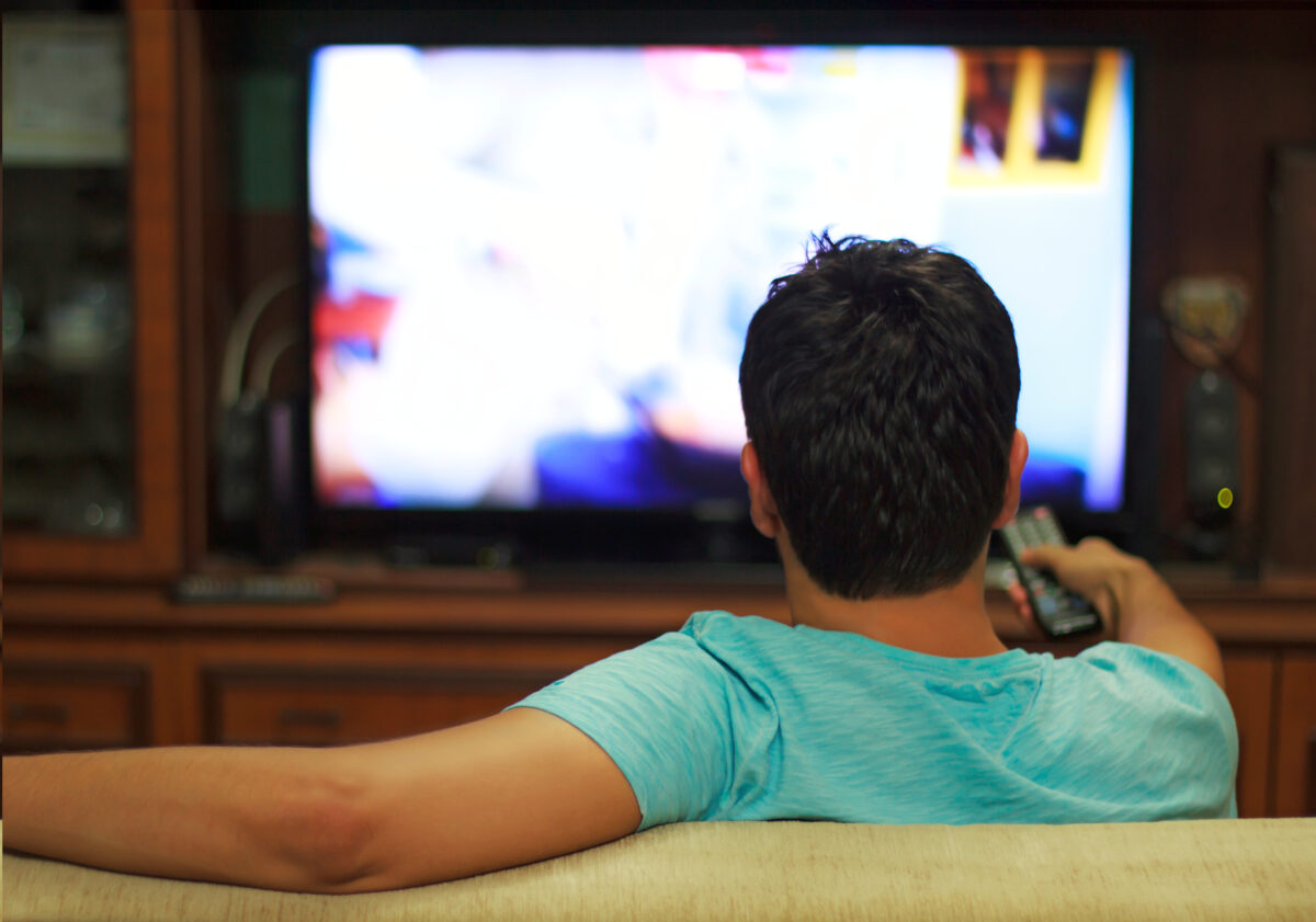 Ofcom has announced it has axed plans to allow more adverts on commercial channels, amid concerns it would lead to a reduction in news content, depicting someone watching TV adverts 