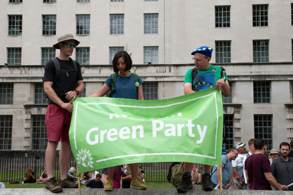 The Green Party has voted to ban 'High Carbon Advertising' following a motion put forward by MP Caroline Lucas at the party's conference, green party supporters with a green banner depicted here