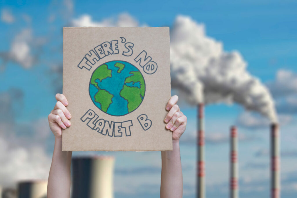 A person holding no planet B placard outside power station. Stealth communications, cultural awareness of progressive and traditional values and not being urban centric are crucial for inspiring climate action among ‘persuadables’, according to ACT Climate Labs research.